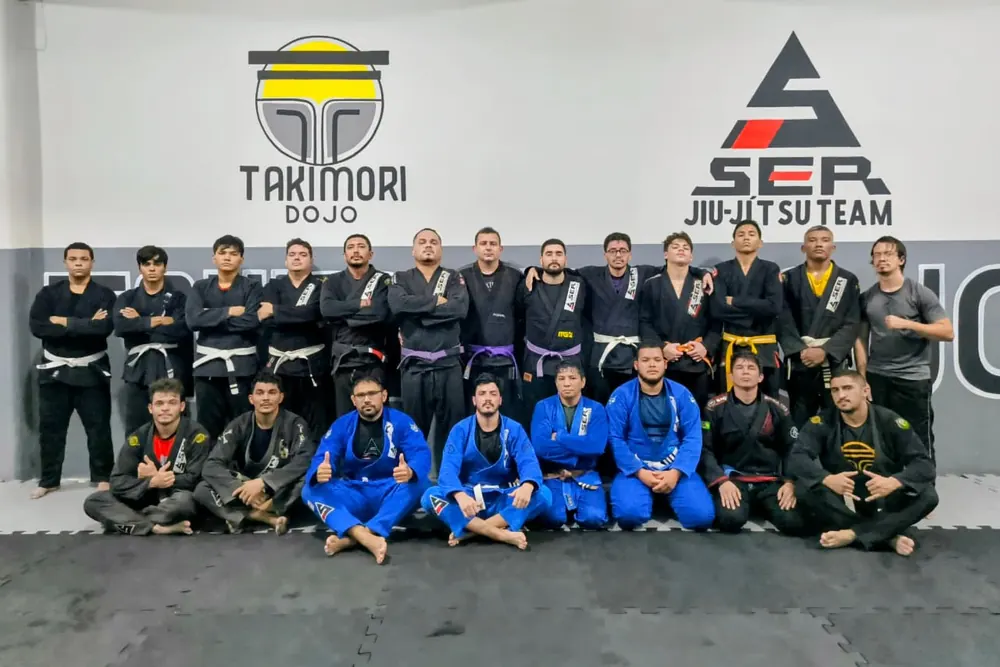 Alunos de kimono posando para foto de turma no dojo